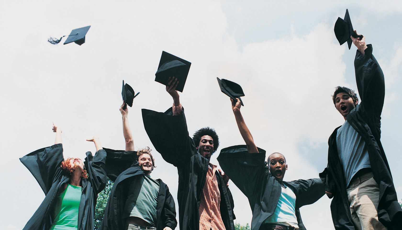 Five Students Jumping for Joy at Graduation
