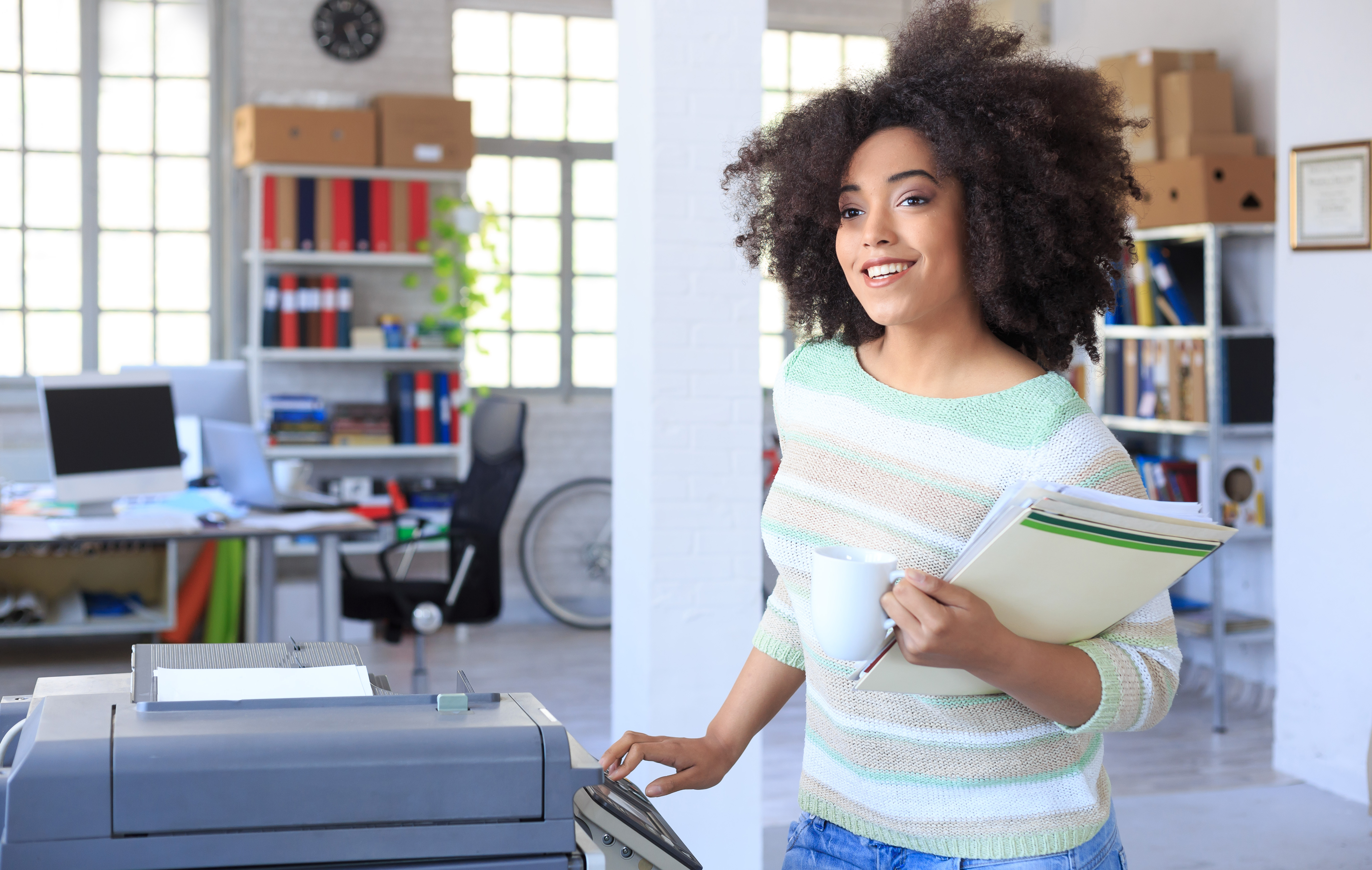 Smiling assistant using copy machine at work