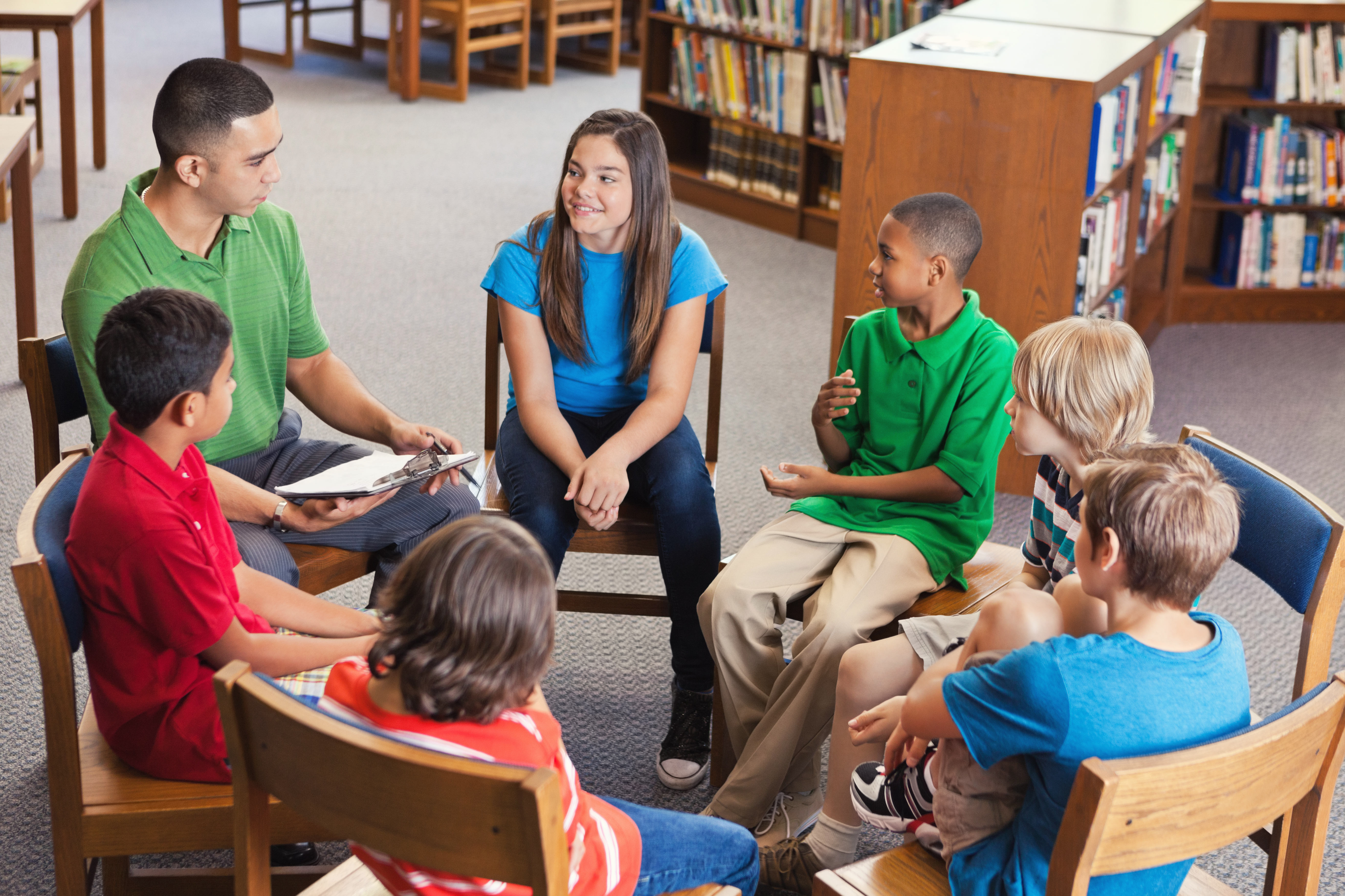 Young teacher leads after school club in library