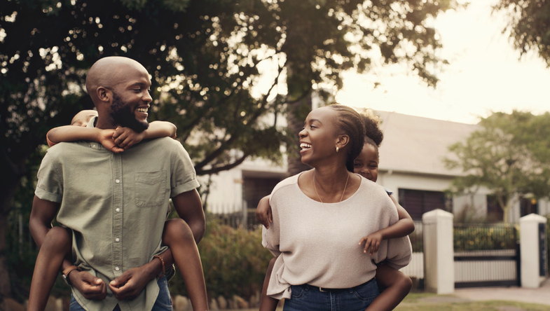 Happy black family, piggyback and walking outdoor together, care or support. African mother, father carrying kids on back or bonding in neighborhood, love or connection of children, mom and dad smile