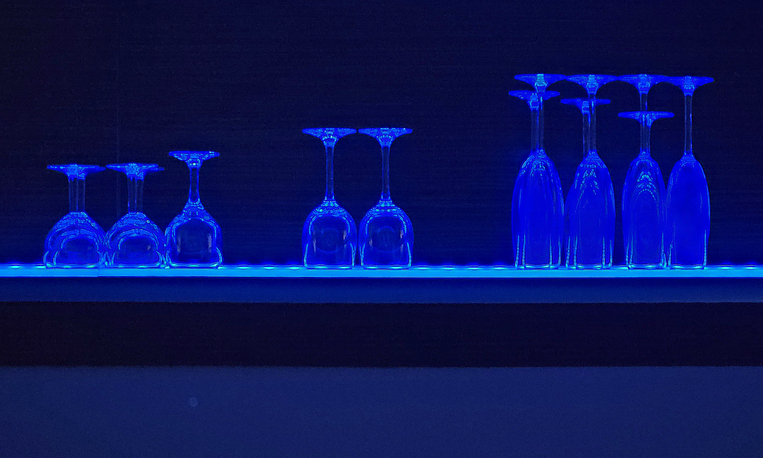 glasses on a bar counter in blue lighting